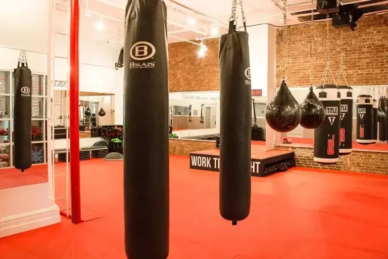 Boxing Studio where our classes happen, has nice red floors, exposed brick, and punching bags.